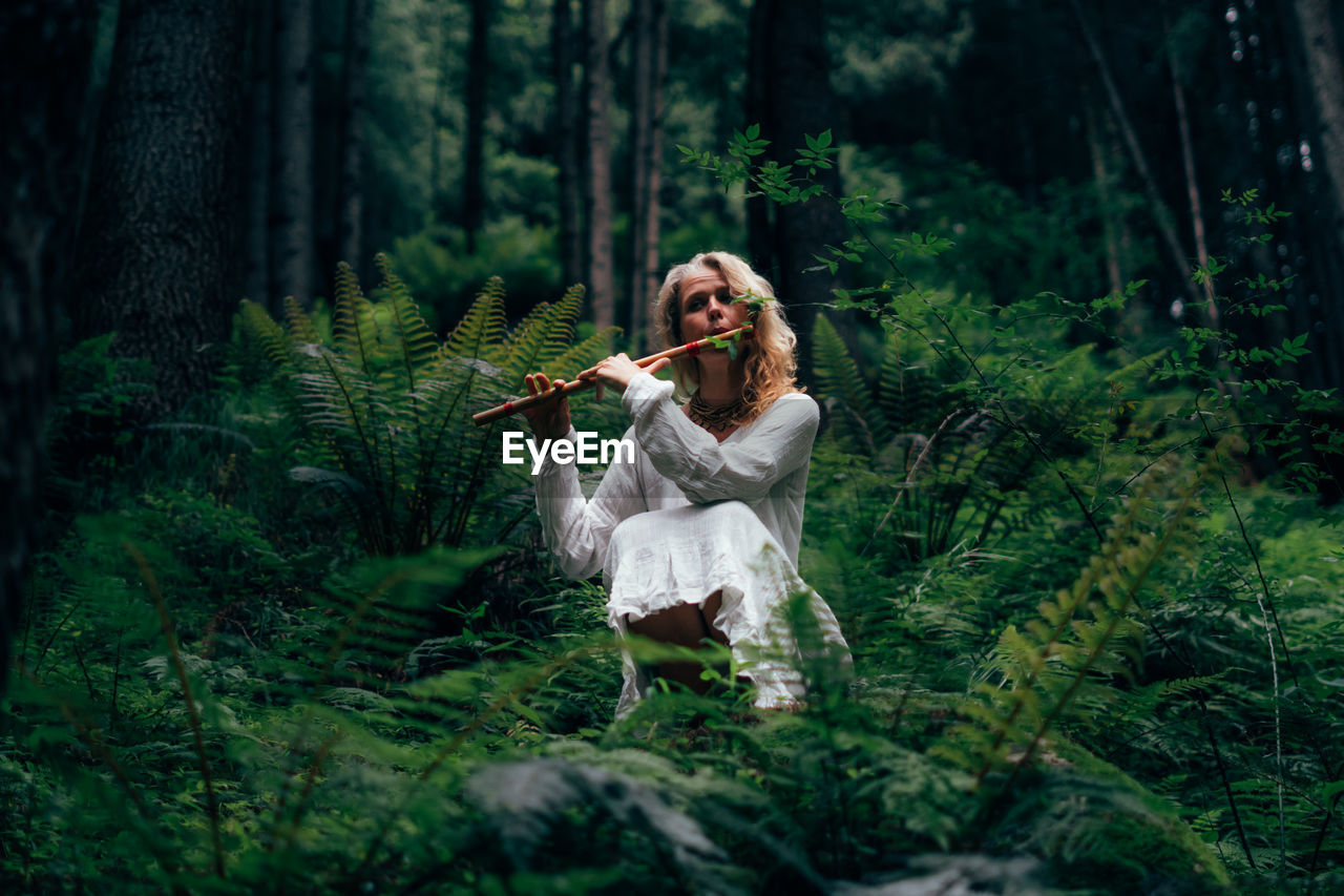 Rear view of woman standing in forest