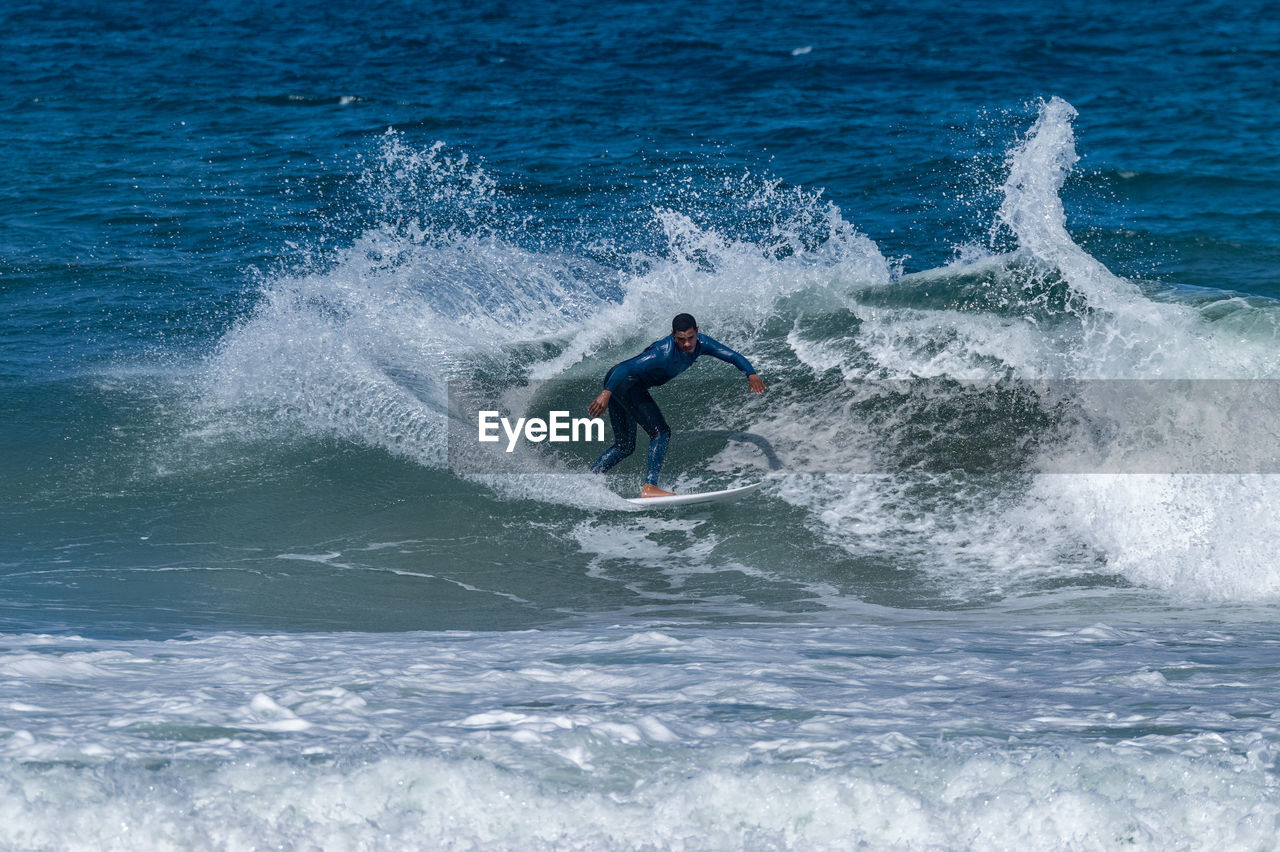 side view of man surfing in sea