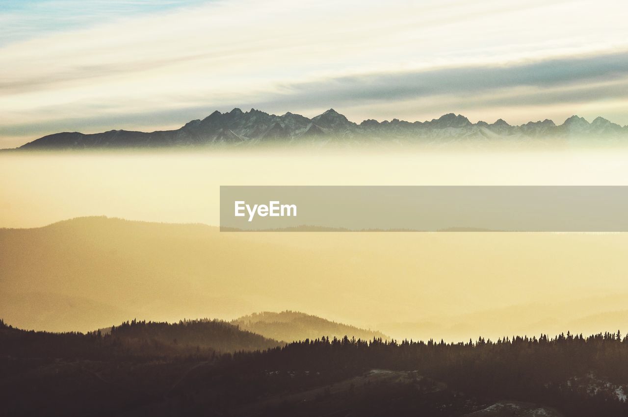 Scenic view of mountains against sky during foggy weather