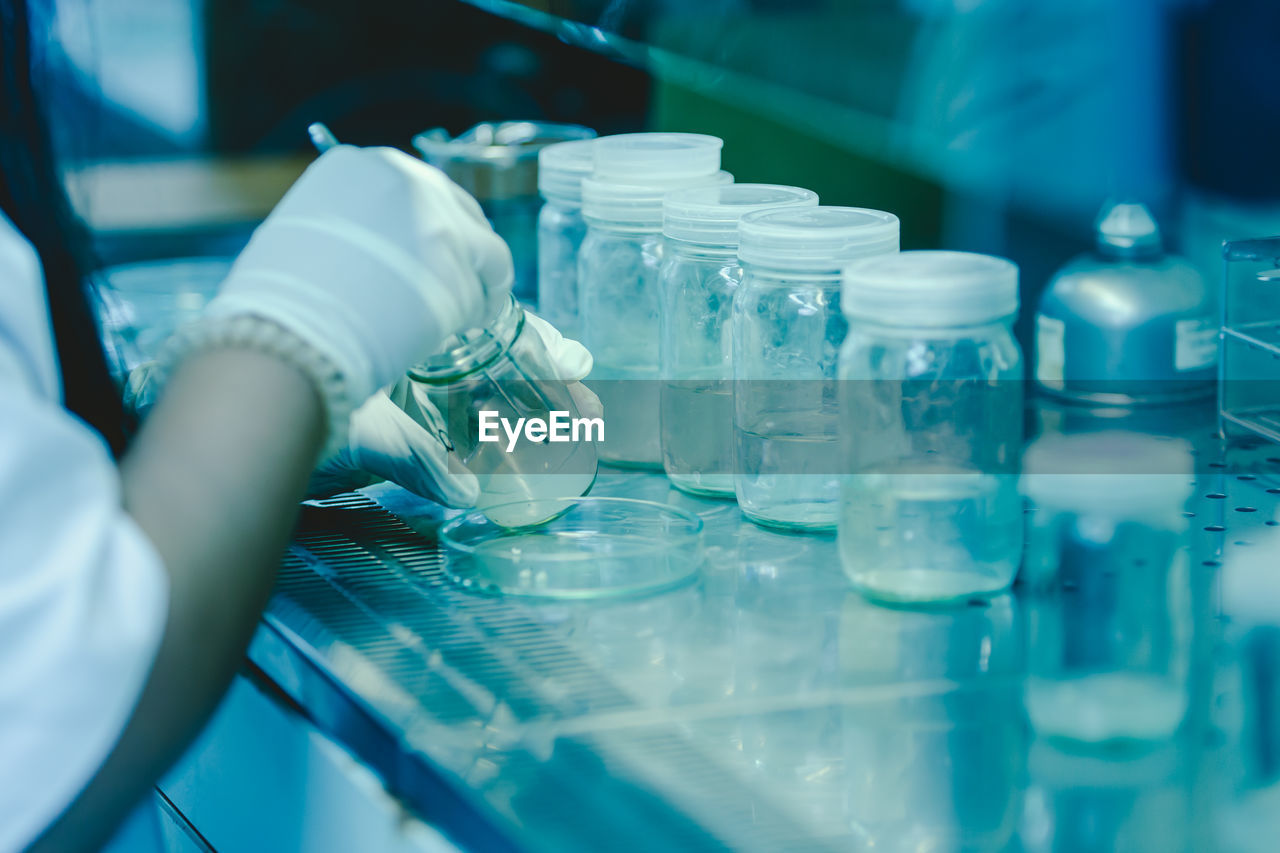 The scientist's hands pouring solvent into the bottles