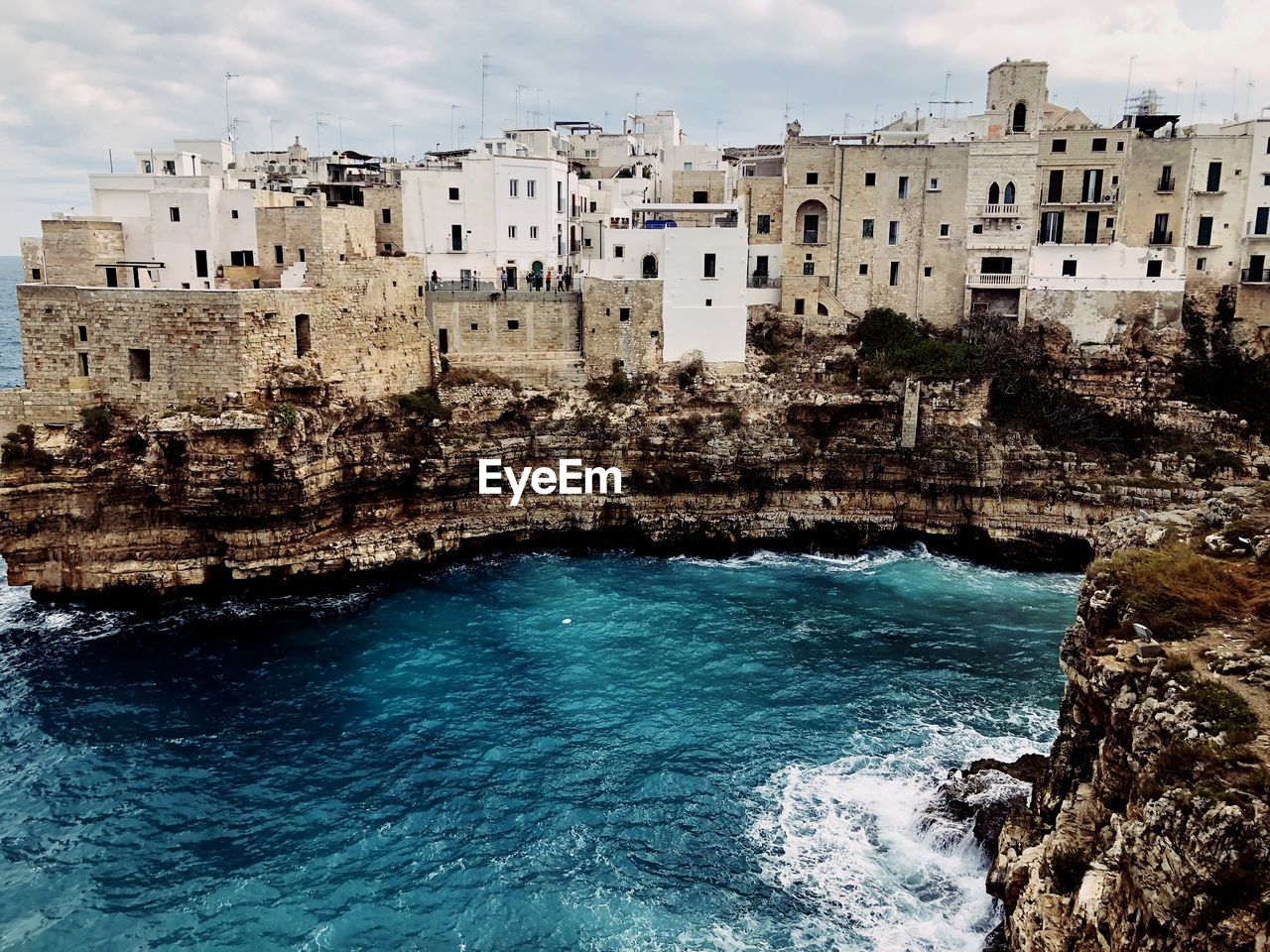 Buildings by sea against sky in city