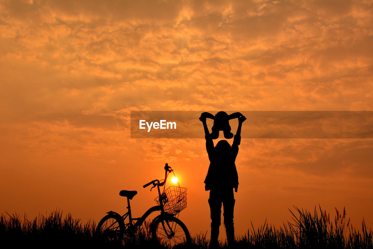 Silhouette of man against orange sky