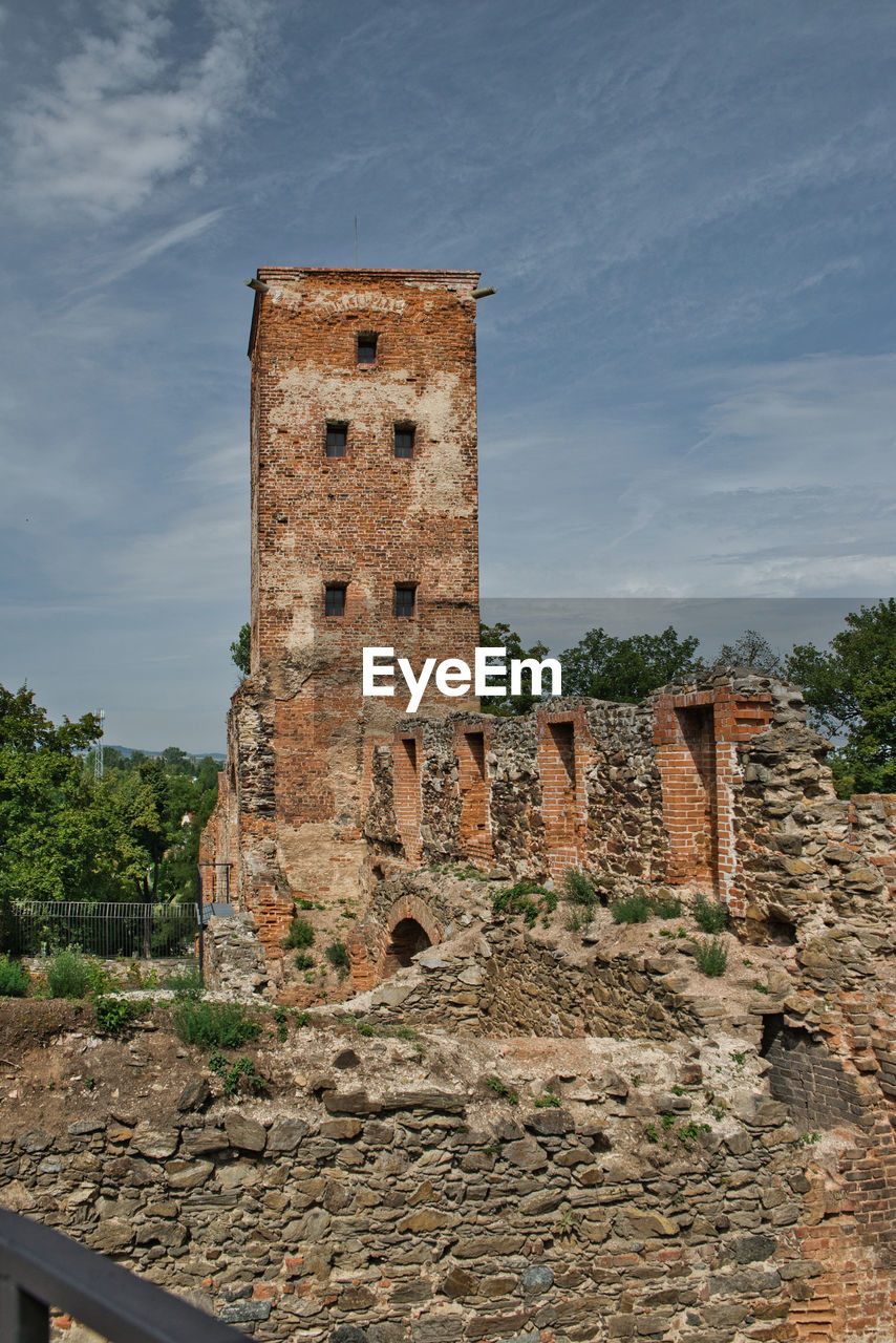 low angle view of old ruins against cloudy sky