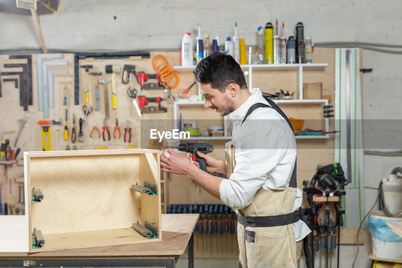 Side view of man working at shop