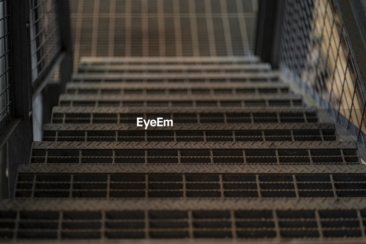 Close up of steel stairs going down under low light. selective focus points.