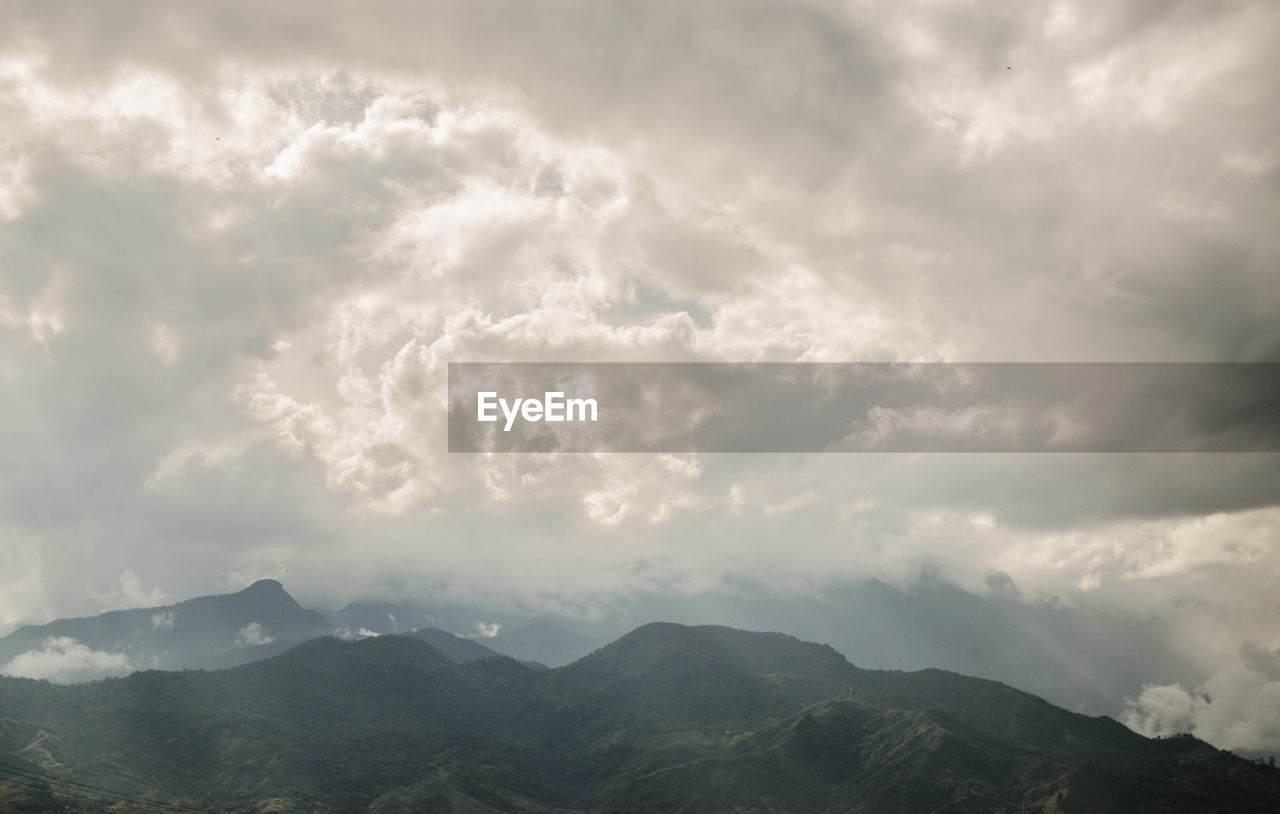 SCENIC VIEW OF STORM CLOUDS OVER MOUNTAINS