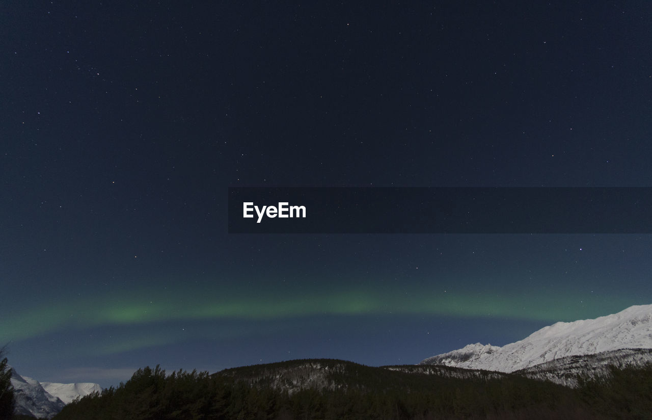 Scenic view of snowcapped mountains against aurora borealis at night