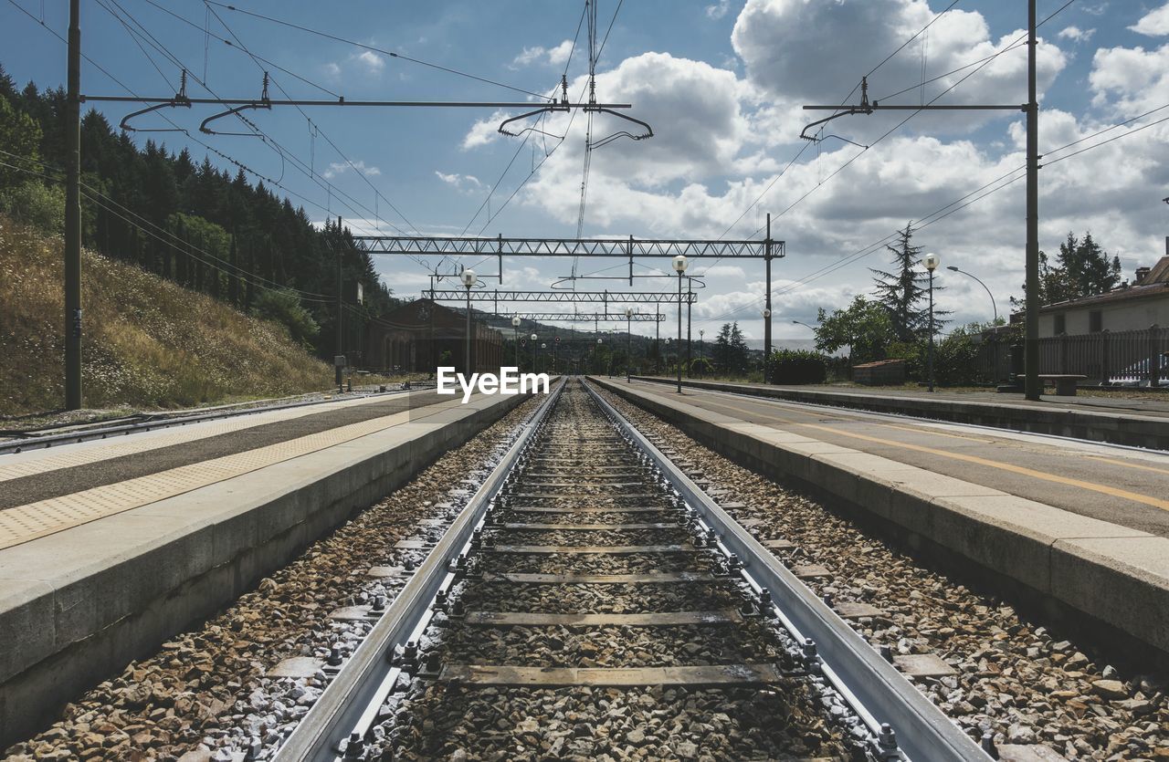 Railroad station against cloudy sky