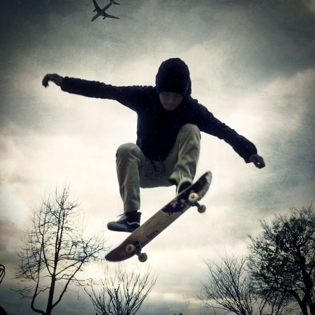 LOW ANGLE VIEW OF GIRL JUMPING IN SKY