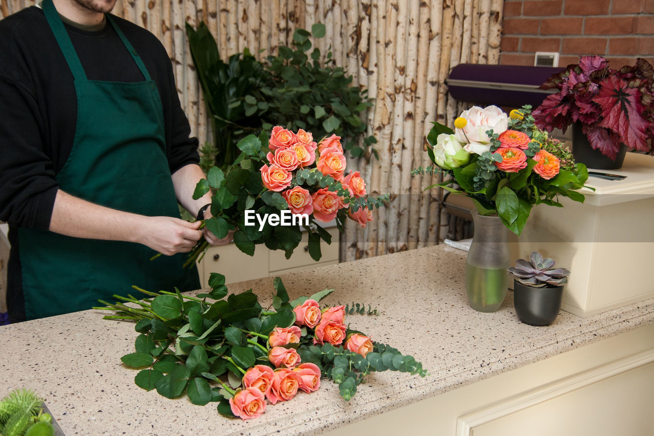 Florist arranging a bouquet of roses