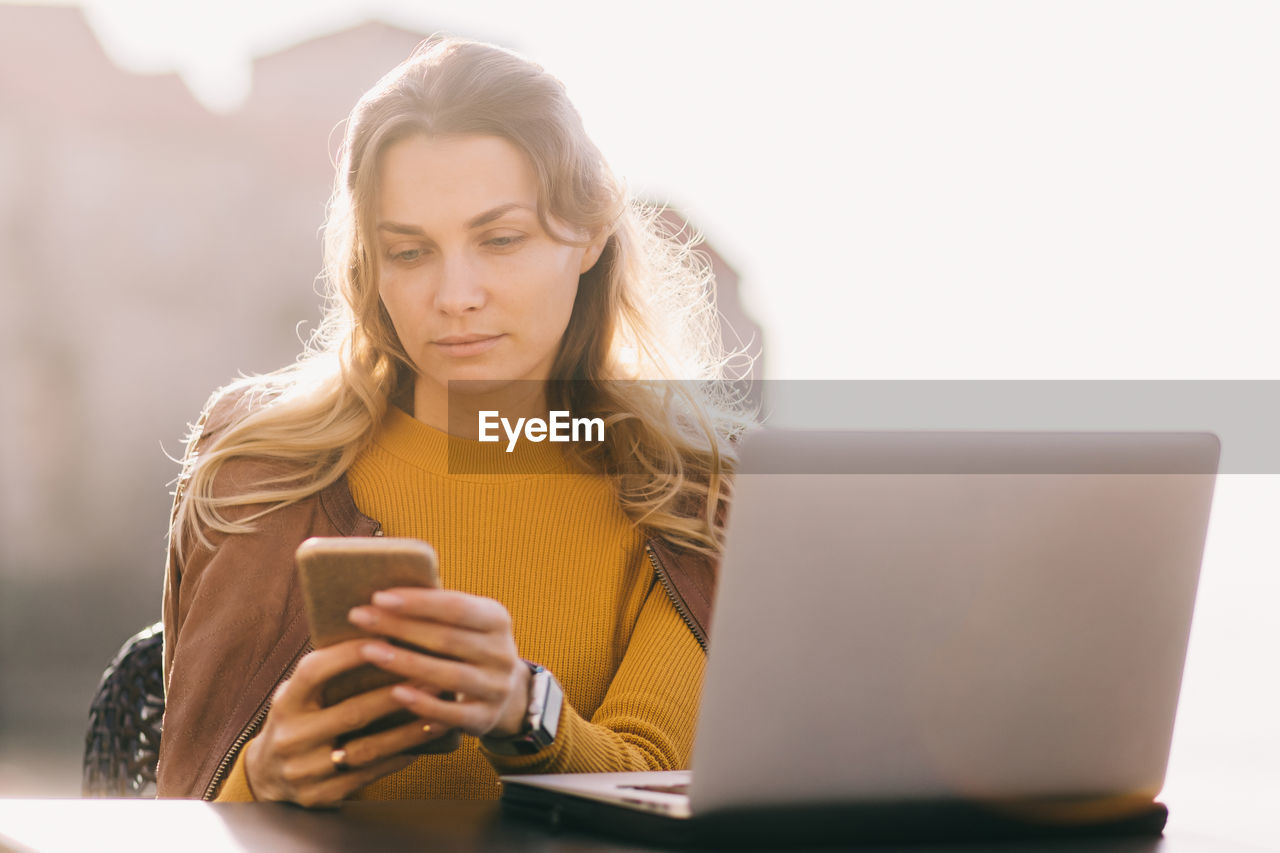 Portrait of young woman using mobile phone