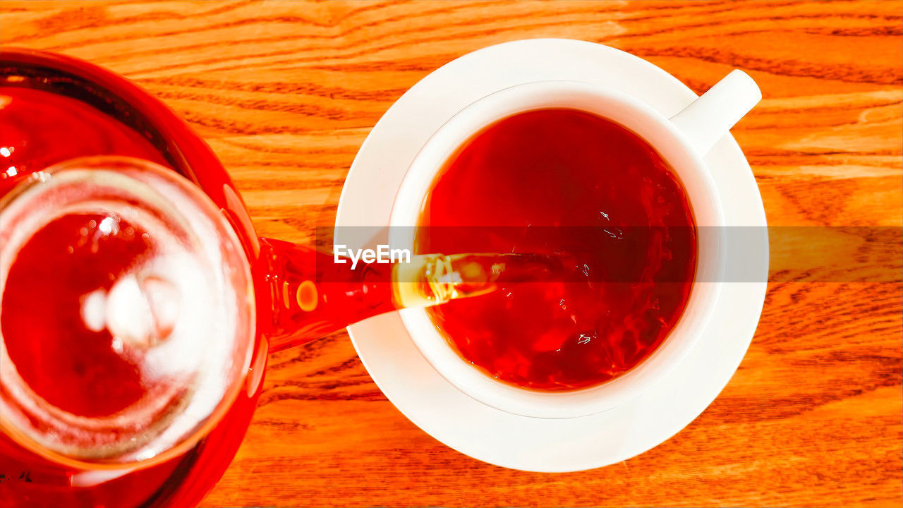 food and drink, drink, refreshment, cup, red, mug, table, hot drink, tea, directly above, indoors, food, tea cup, high angle view, no people, crockery, wood, still life, saucer, produce, freshness, close-up, glass, drinking glass, household equipment, wellbeing