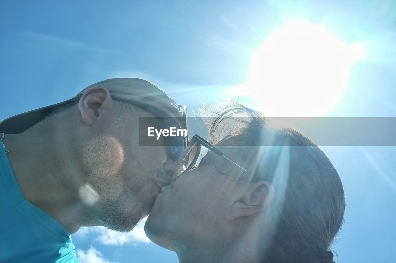 Low angle view of couple kissing outdoors