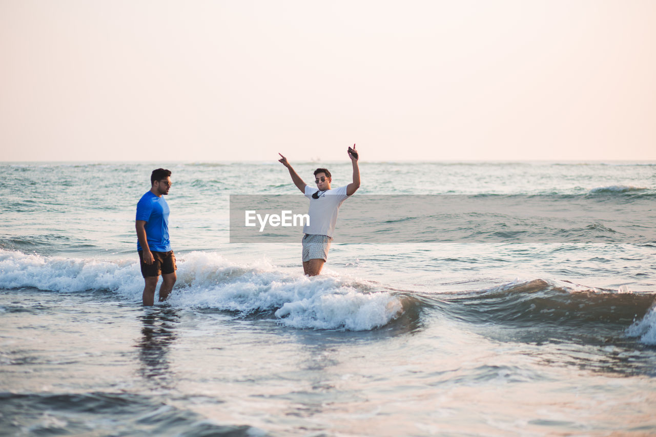 Two people enjoying themselves in the water by the beach