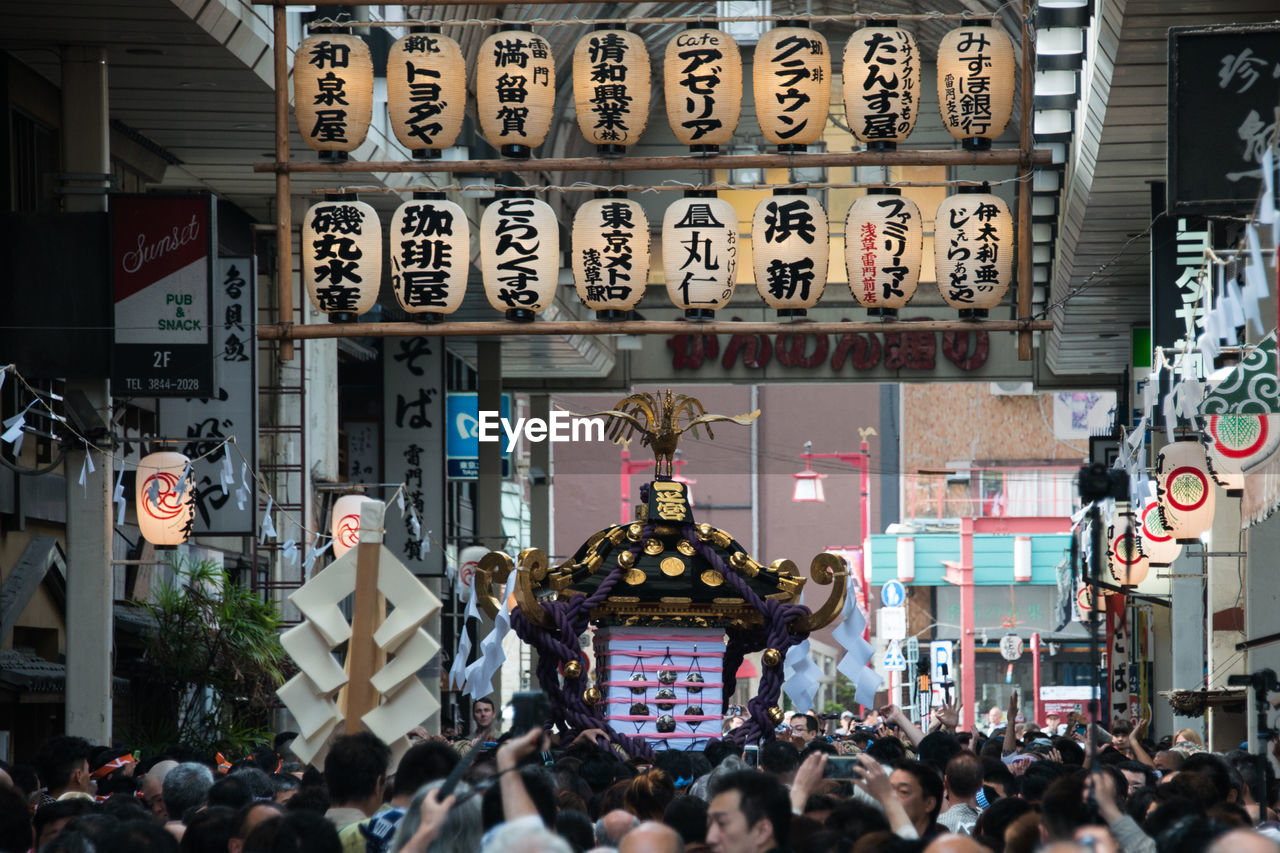 Crowd carrying mikoshi in city during sanja matsuri