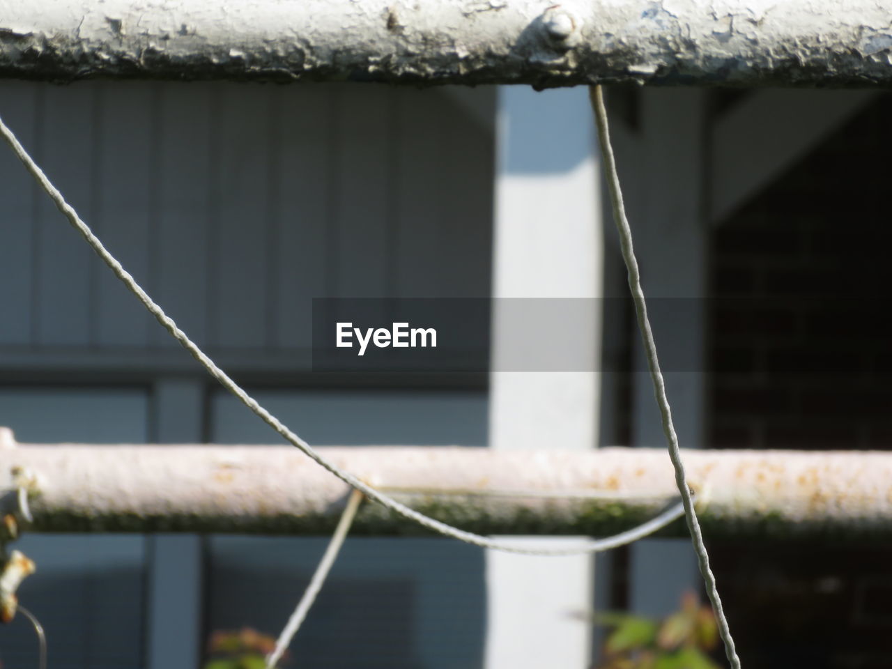 CLOSE-UP OF METAL FENCE AGAINST BUILDINGS