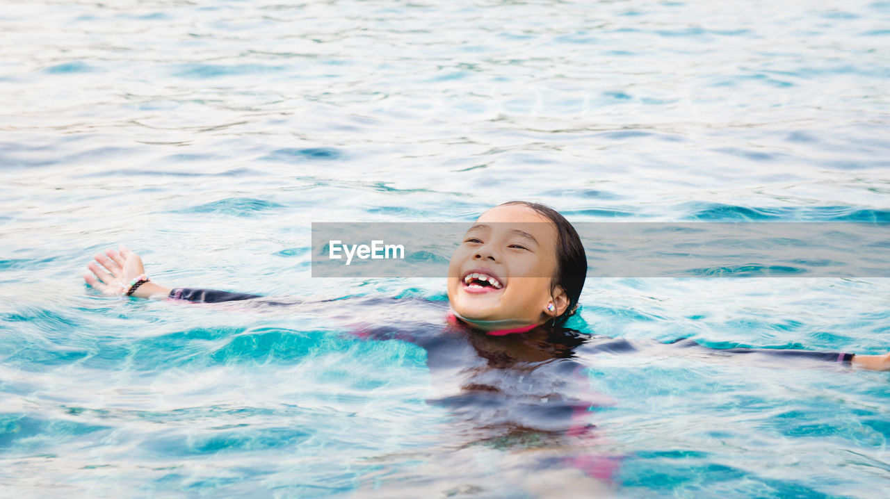 High angle view of smiling girl swimming in sea