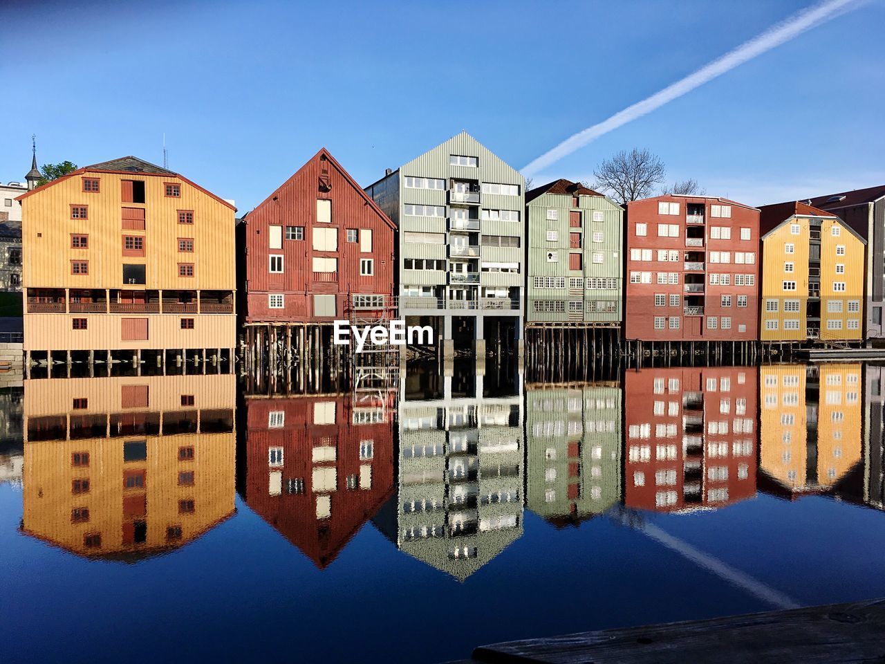 Reflection of buildings in river against blue sky