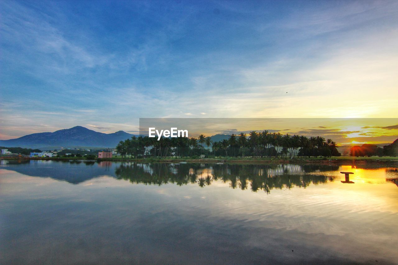 Scenic view of lake against sky at sunset