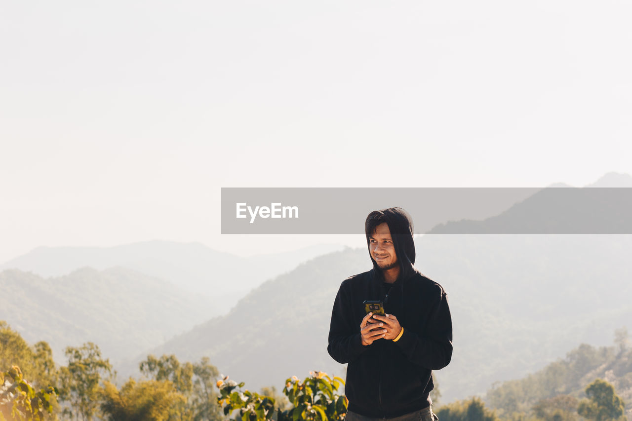 Man standing on mountain against clear sky