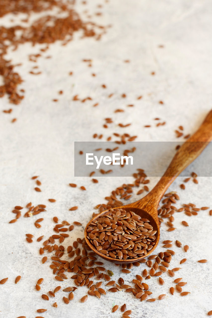 Raw flax seeds in a wooden spoon close up