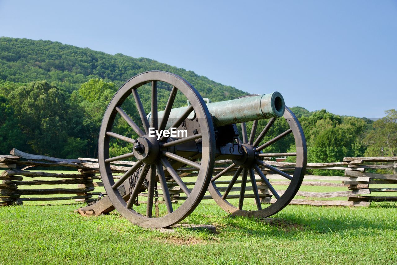 Cannon  wheel on field against clear sky