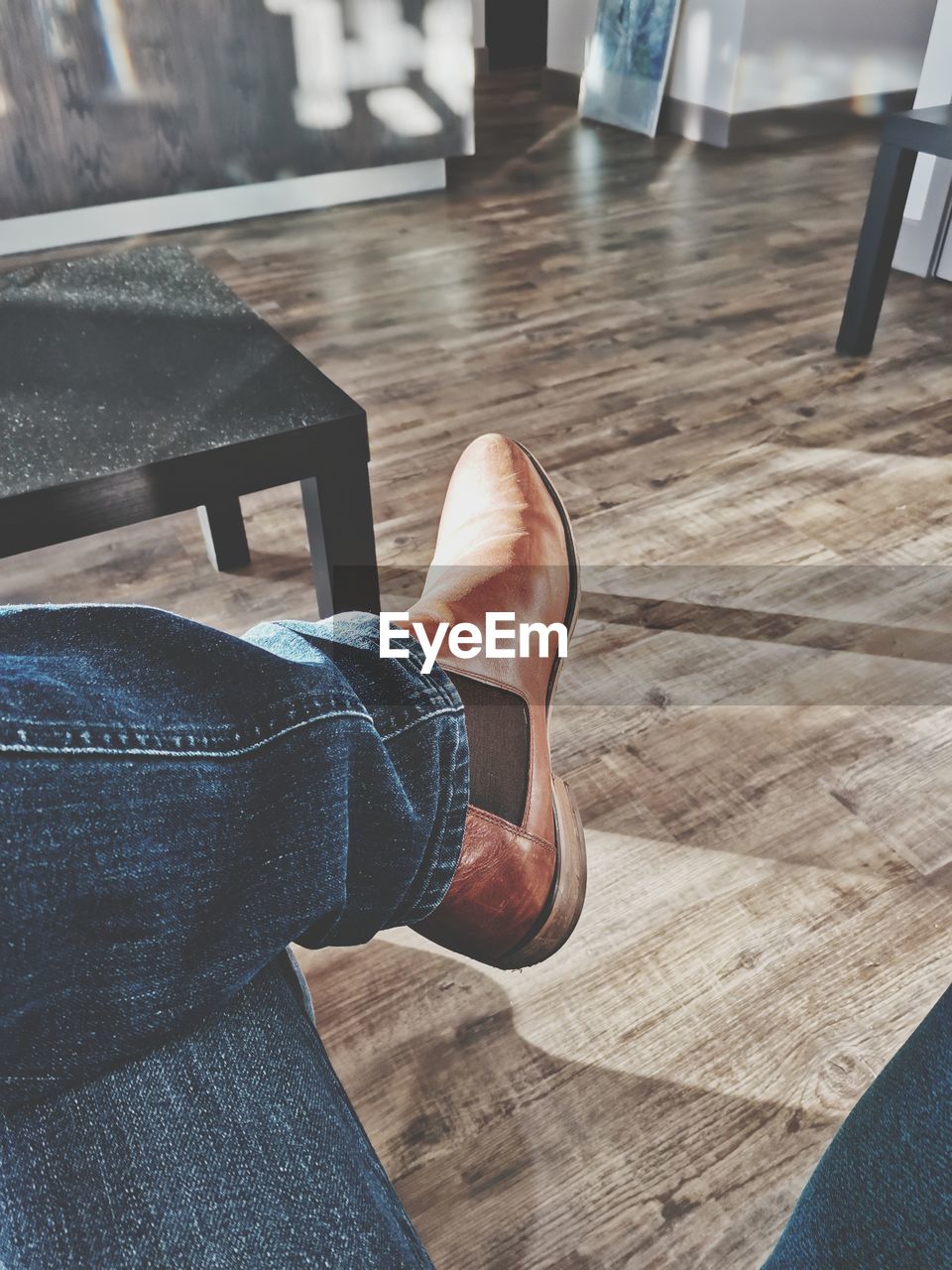 LOW SECTION OF MAN WEARING SHOES ON FLOOR AT HOME