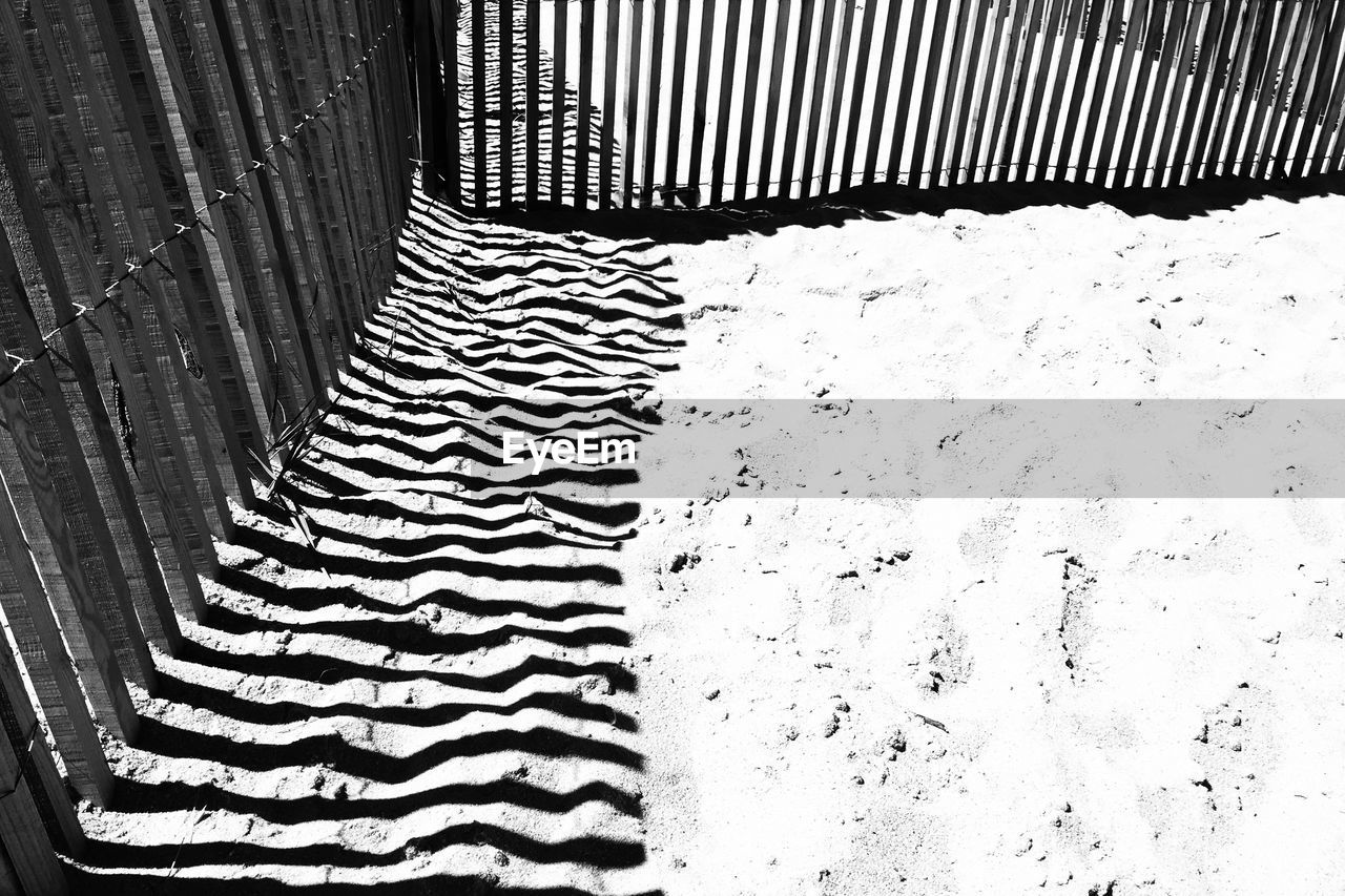 High angle view of sand surrounded by fence