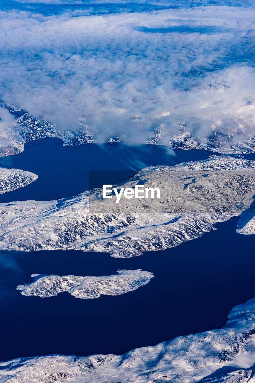 AERIAL VIEW OF SNOWCAPPED MOUNTAIN AGAINST BLUE SKY