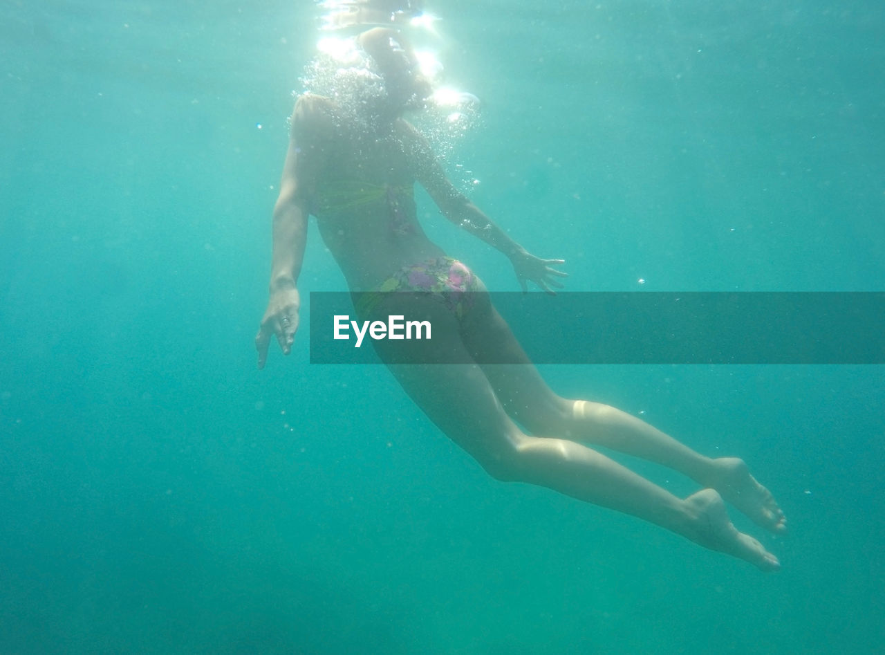 Full length of young woman swimming in sea