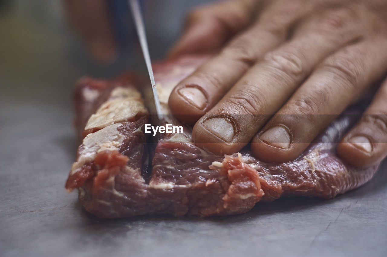 hand, food, food and drink, meat, one person, dish, indoors, close-up, adult, freshness, cuisine, holding, baked, selective focus, occupation, focus on foreground, red meat