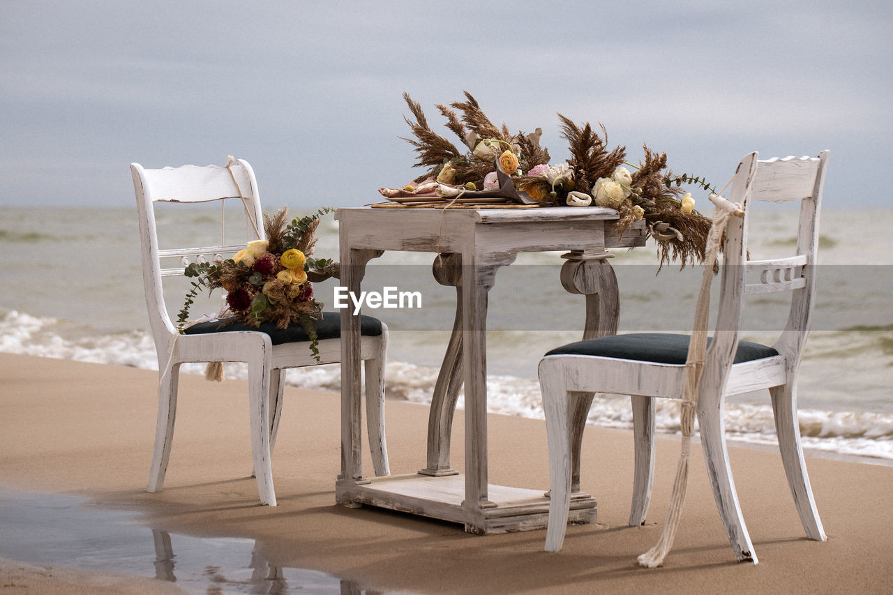 CHAIRS AND TABLE AT BEACH