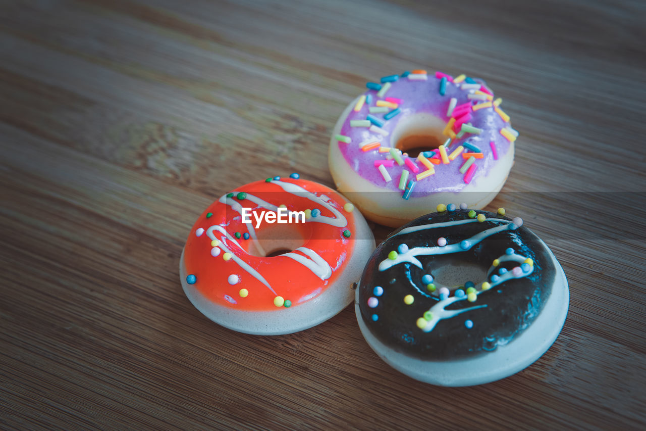 High angle view of multi colored donuts on table