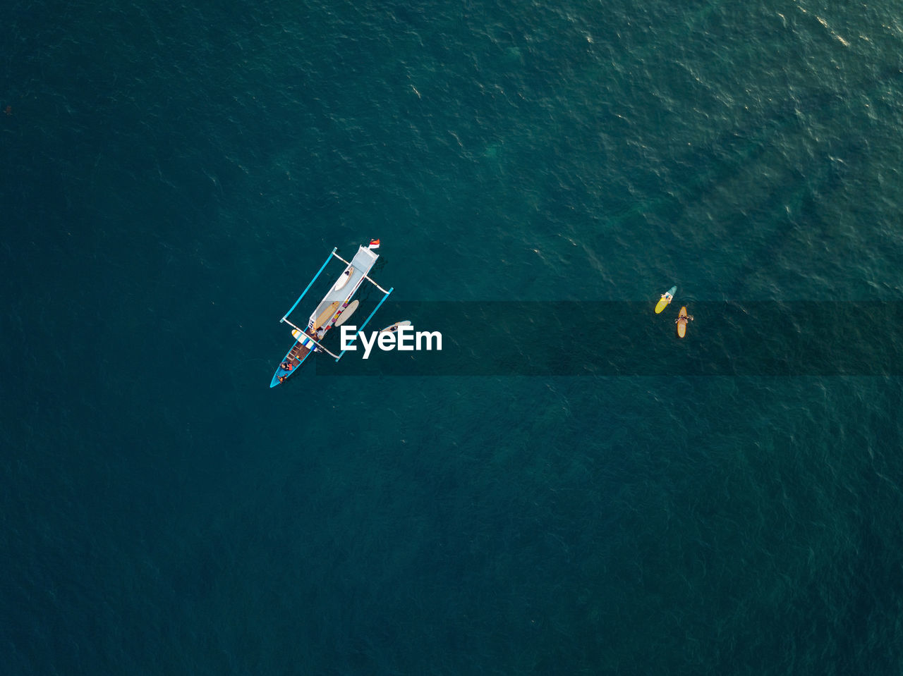 Aerial view of surfers and boat in the ocean, lombok, indonesia