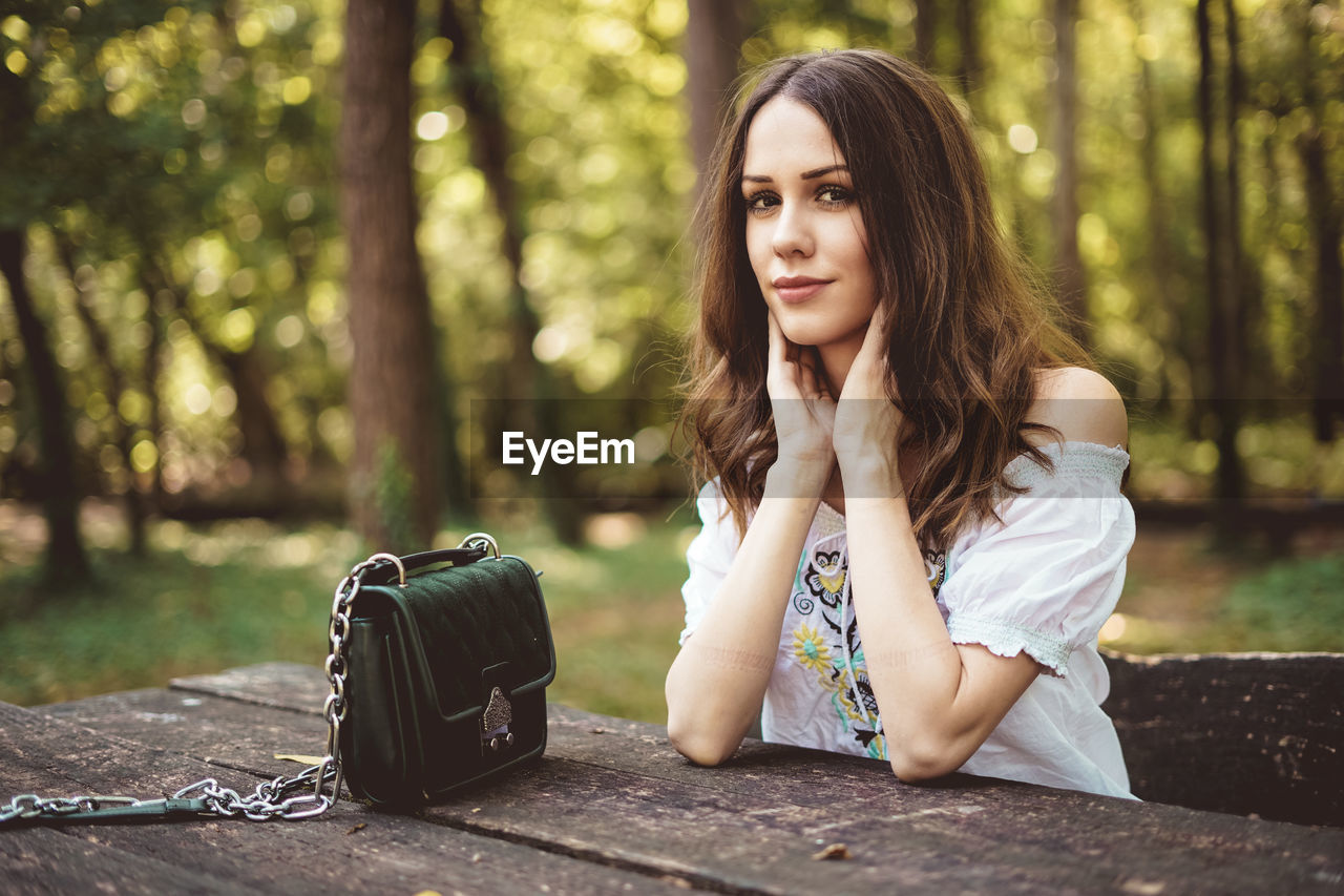 Portrait of beautiful young woman sitting outdoors