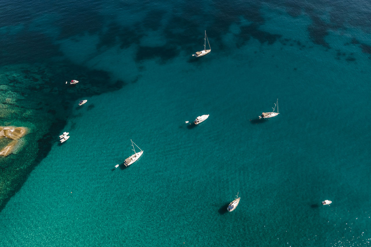 water, nautical vessel, transportation, sea, high angle view, aerial view, mode of transportation, nature, turquoise colored, beauty in nature, scenics - nature, travel, ocean, land, day, travel destinations, outdoors, no people, tranquility, ship, vehicle, sailing, coast, tranquil scene, beach, blue, idyllic, sailboat