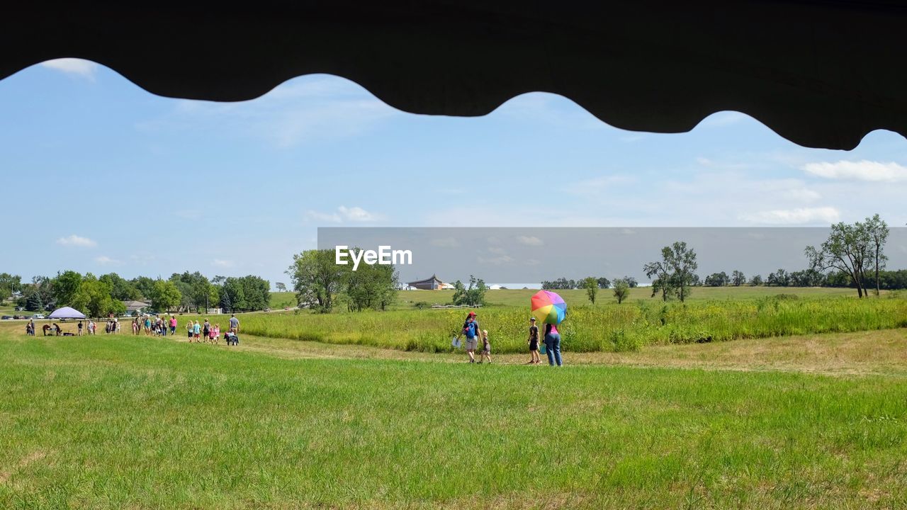 PEOPLE IN FIELD AGAINST SKY