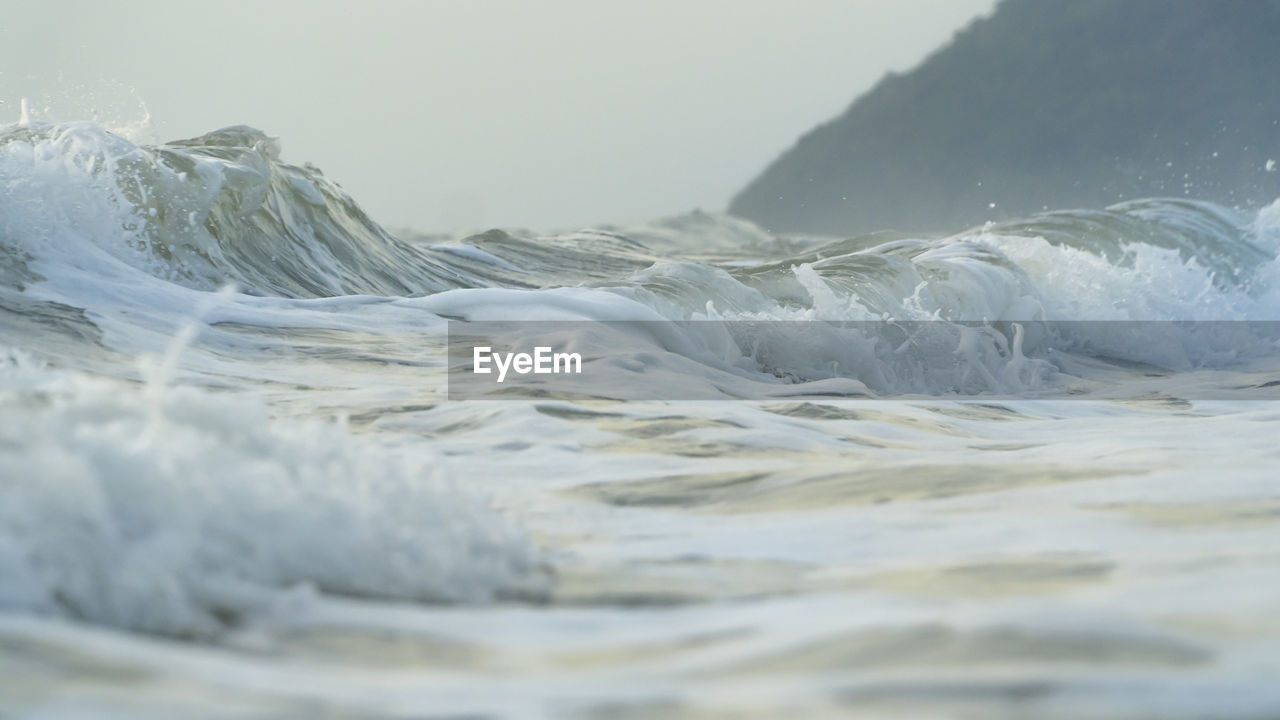 SURFACE LEVEL OF WAVE ON SHORE AGAINST SKY