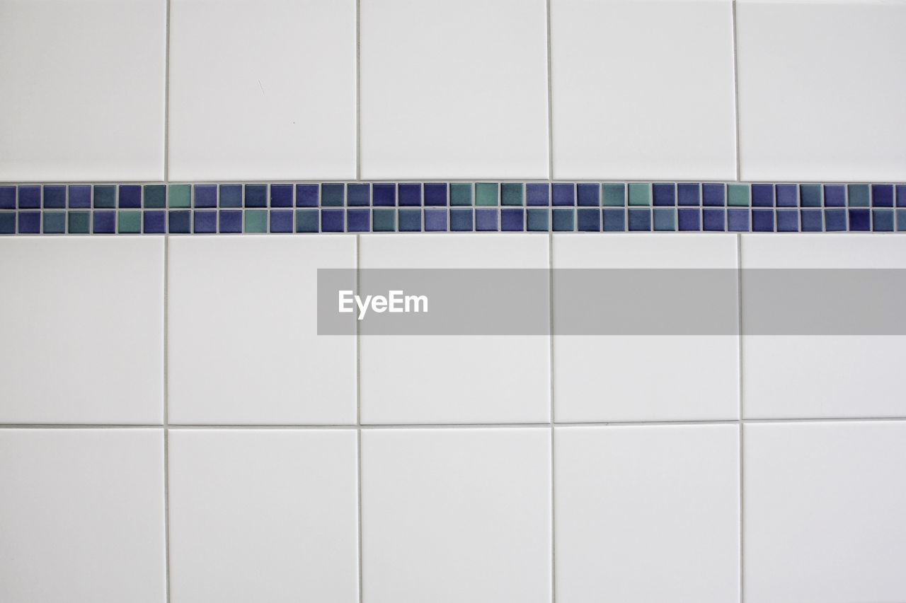 Close-up of white tiled wall