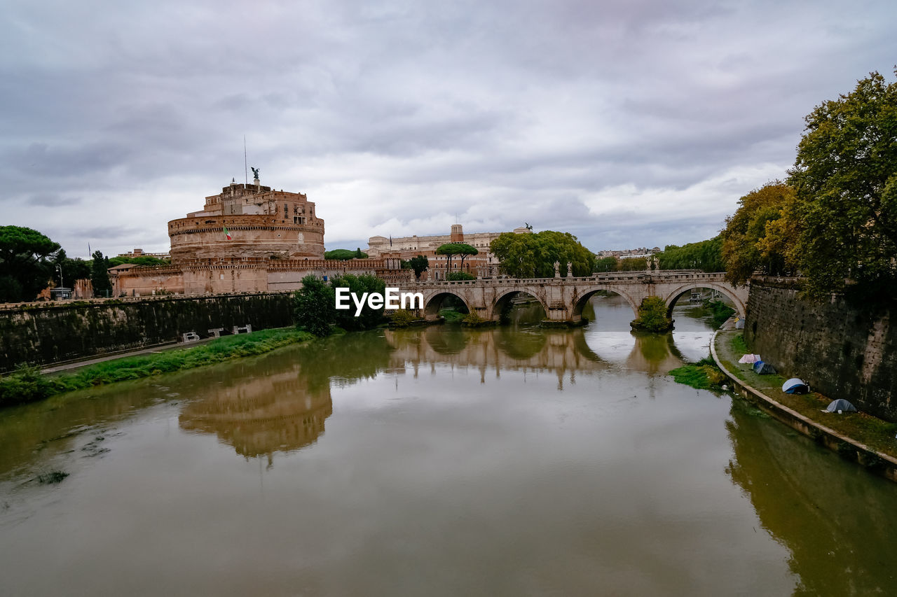 Castelo sant'angelo and ponte sant'angelo over tiber river - cloudy overcast grey day - rome, italy
