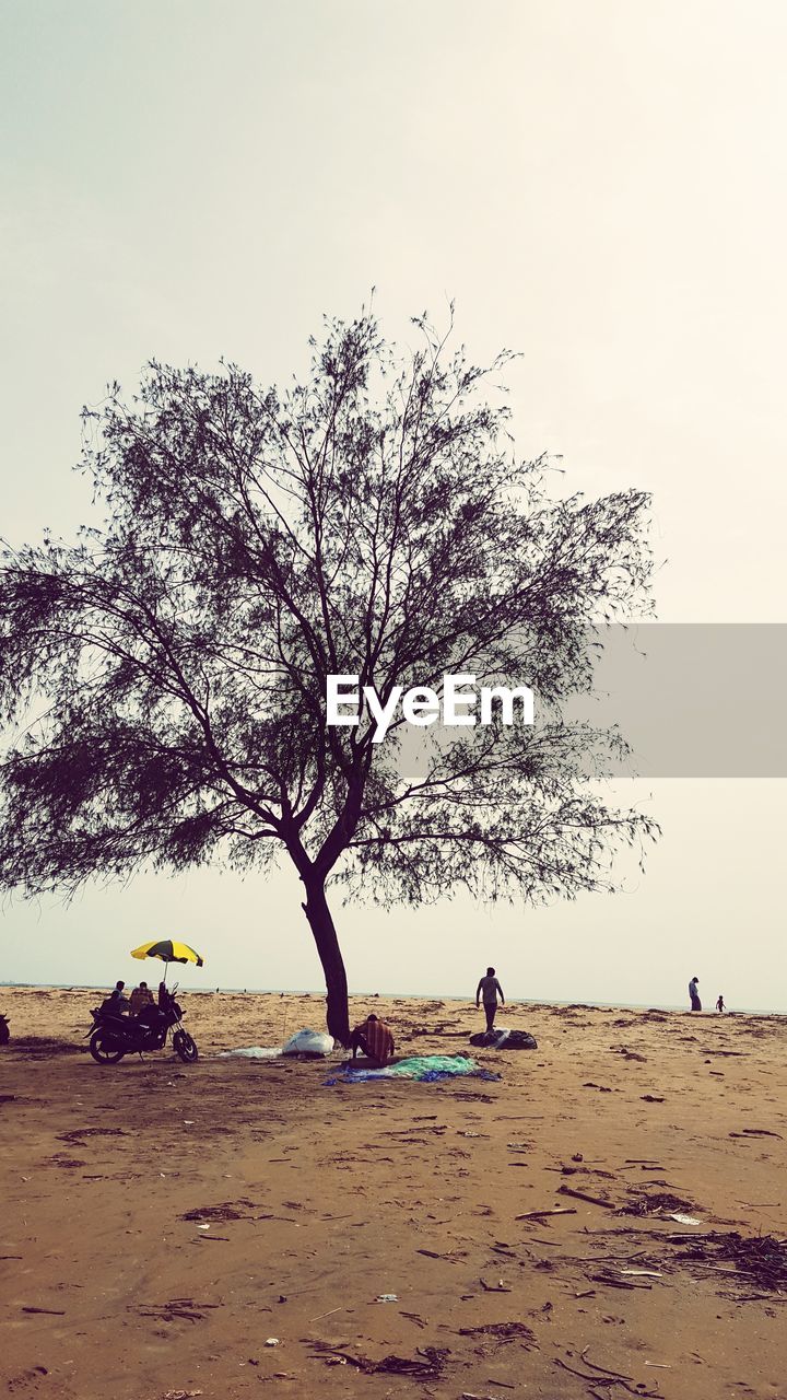 PEOPLE ON BEACH AGAINST SKY