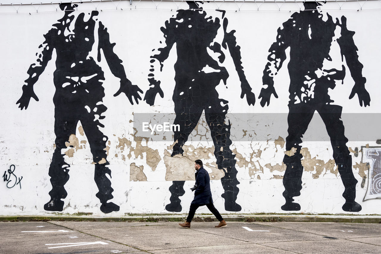 SILHOUETTE MAN STANDING BY ROAD