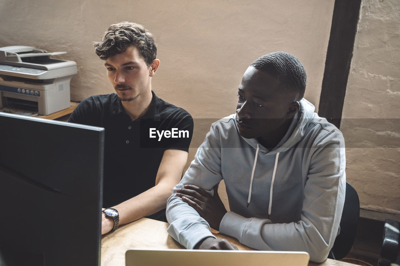 Computer programmers working on computer at workplace