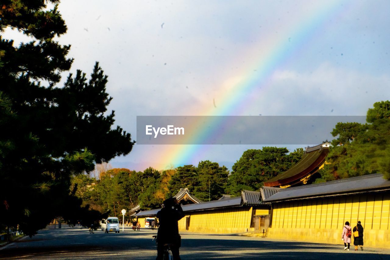 SCENIC VIEW OF RAINBOW OVER STREET IN CITY AGAINST SKY