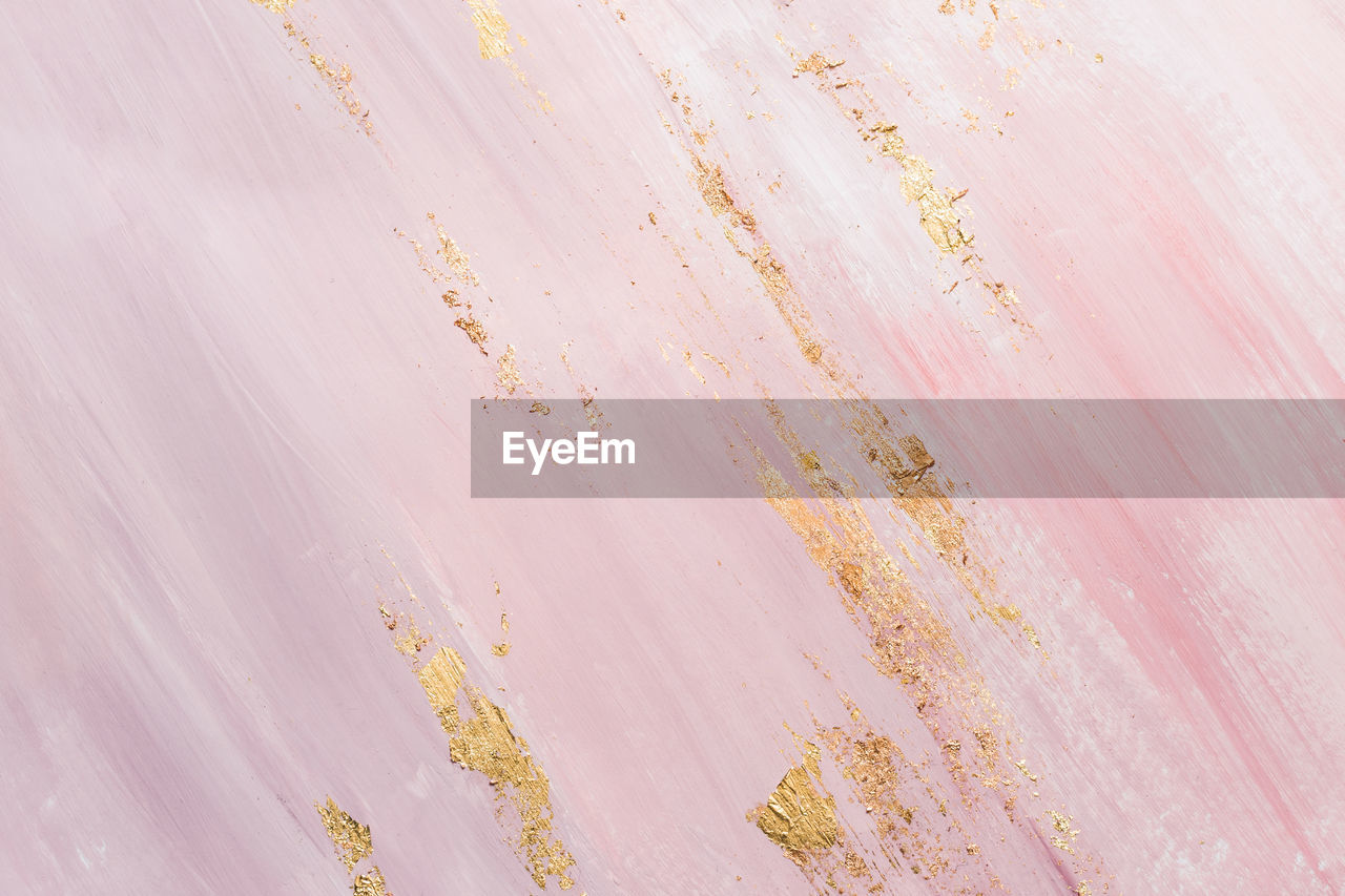 Delicate pink marble background with gold brushstrokes. place for your design.