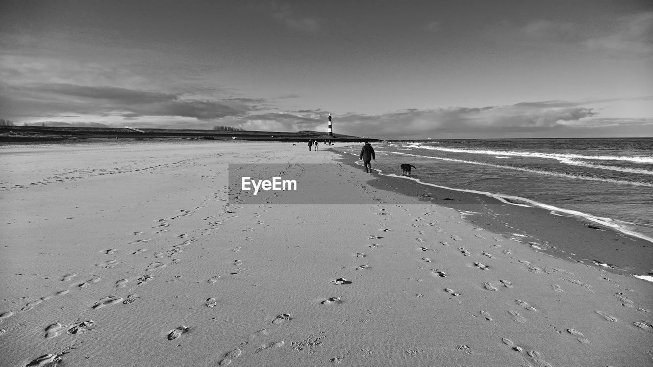 PEOPLE AT BEACH AGAINST SKY