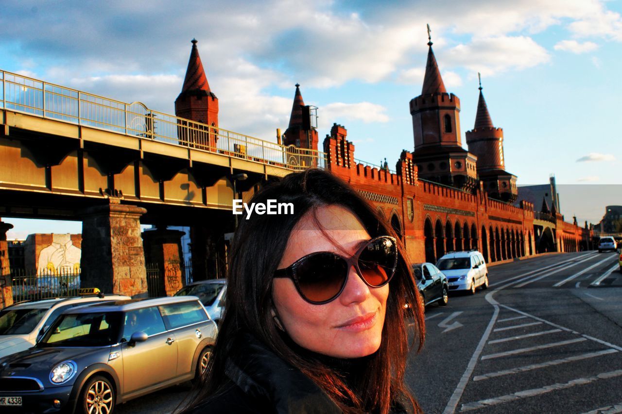 Young woman standing against oberbaum bridge during sunset