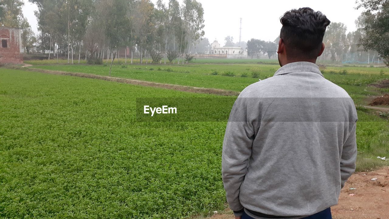 Rear view of man standing on field