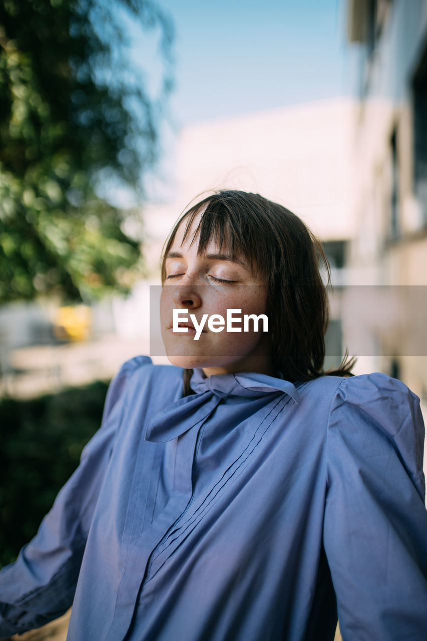 PORTRAIT OF WOMAN WITH EYES CLOSED LOOKING AWAY