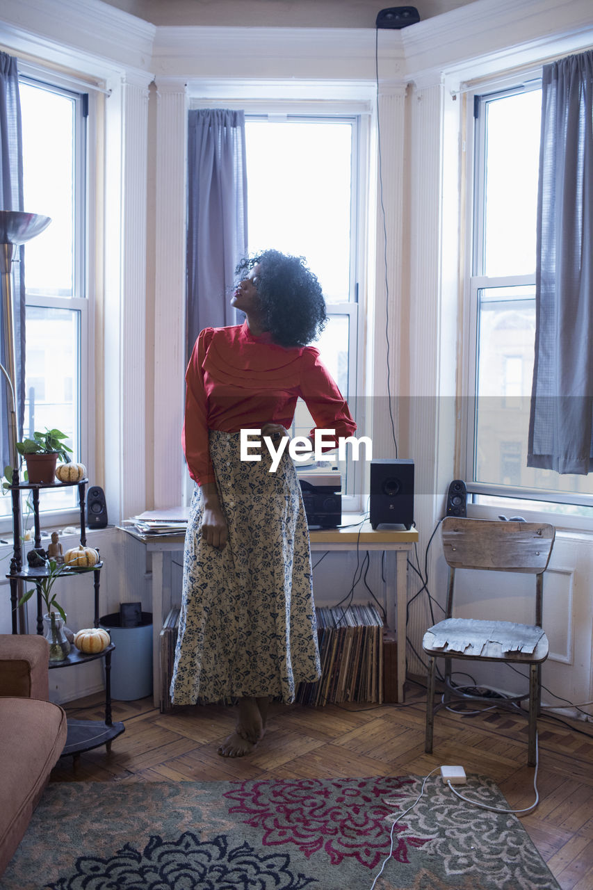 A young woman posing by windows